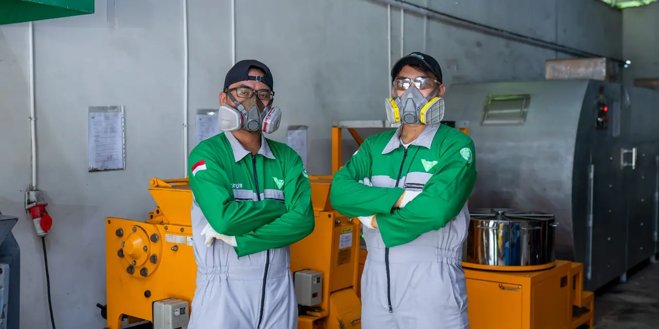 Laboratory staff in coveralls and respirators beside the sample preparation equipment